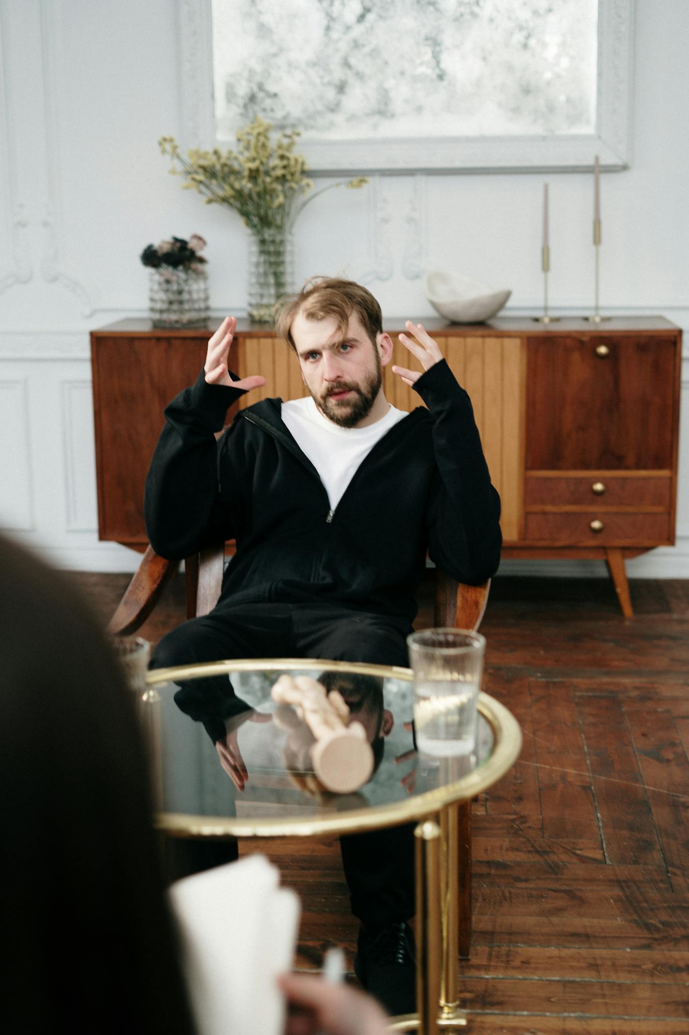 Man engaged in a discussion with a therapist in a modern office setting.